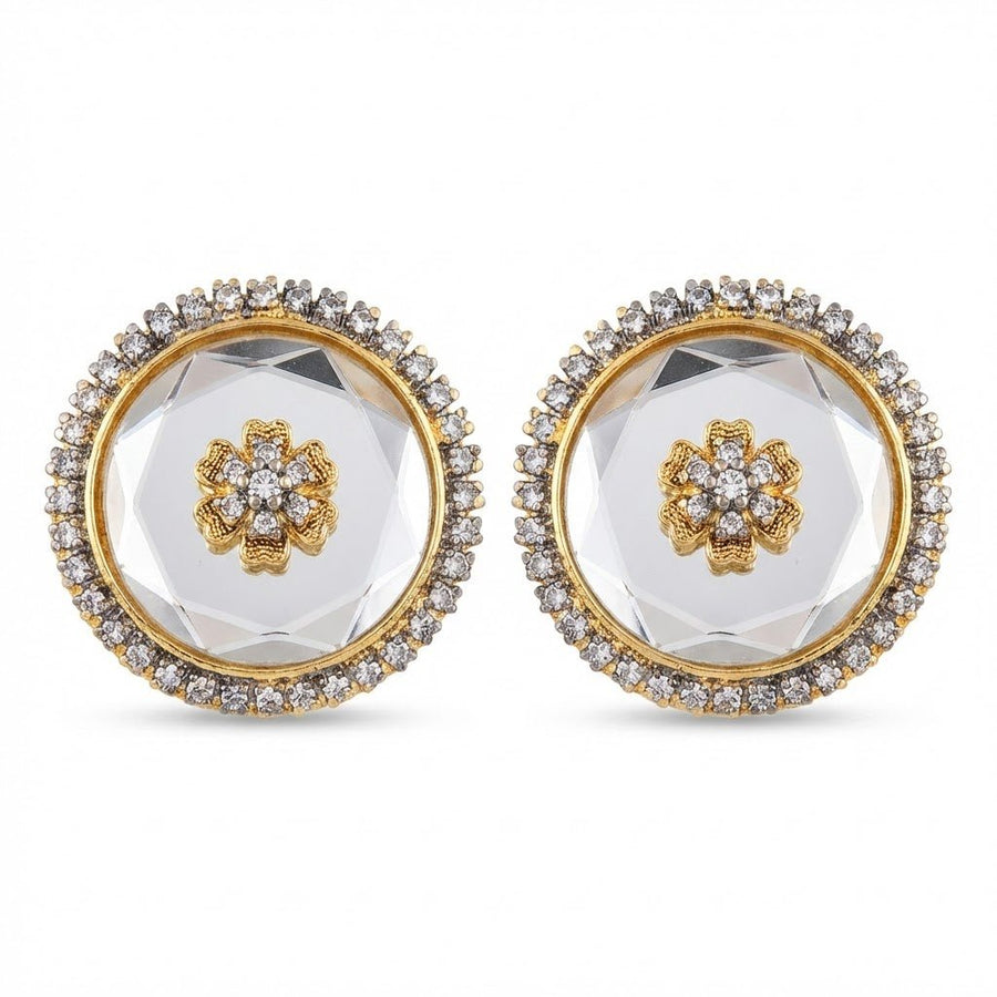 Close-up of emerald green round stud earrings on natural beige smooth stones with dried yellow flowers nearby