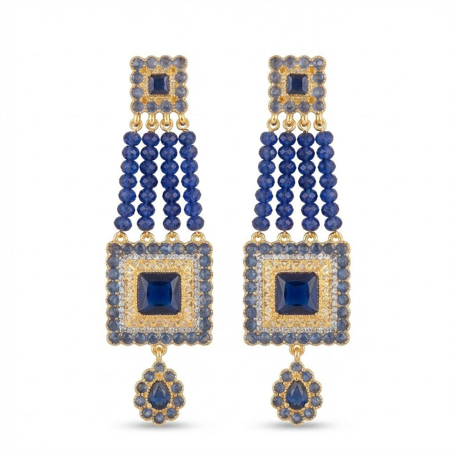Blue gemstone bead earrings displayed on white textured paper background in natural light