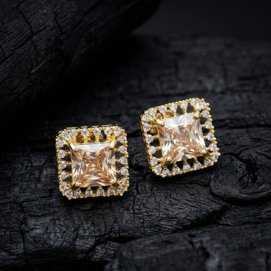 Champagne halo stud earrings photographed on textured dark background highlighting refined craftsmanship