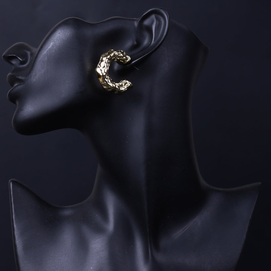 Side profile showcasing silver textured hoop earring on black mannequin