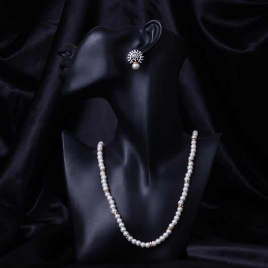 Black mannequin wearing matching pearl necklace and crystal floral earrings against black silk background