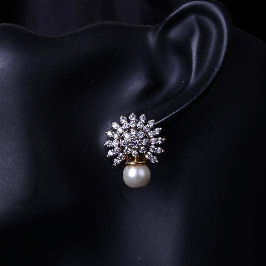 Close-up of pearl drop earrings with floral crystal design on black mannequin