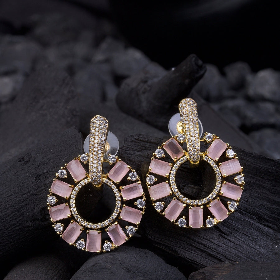 Gold plated pink stone circle drop earrings displayed on black textured surface