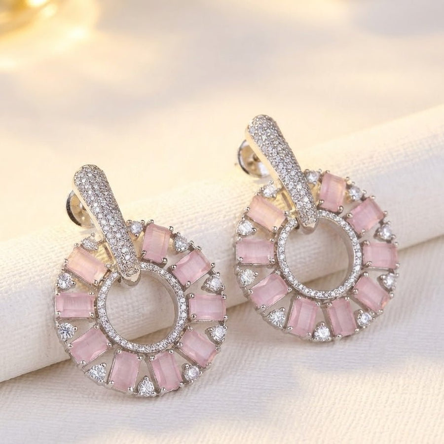 Pink stone circle drop earrings sparkling under studio lighting on white background