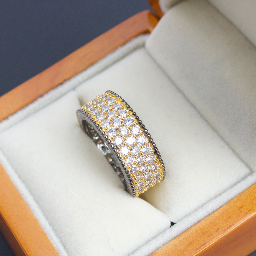 Two-tone cubic zirconia band ring displayed inside wooden jewelry box with plush white lining