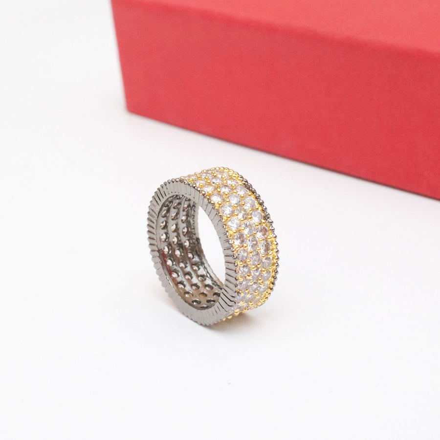 Close-up image of the two-tone cubic zirconia band ring with gold and silver tones on white surface with red box edge visible